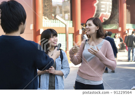 Foreign tourists undergoing street interviews 91229564