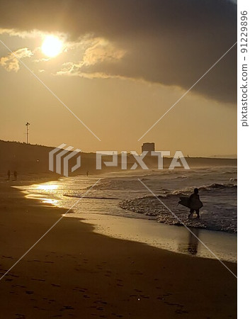 A surfer, a shining beach in the rainy season seen from the Chigasaki coast in Chigasaki City, Kanagawa Prefecture [June] 91229896