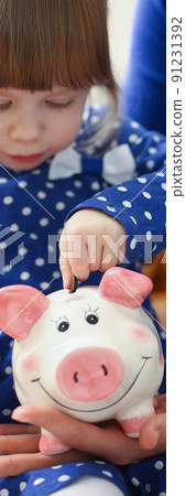 Cute little child putting coin cash into piggy bank container Cute little child putting coin cash into piggy bank container 91231392
