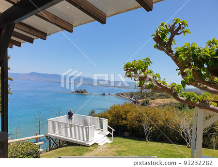 A man wearing a hat is photographing the scenic view of a beautiful bay at Akamas Peninsula, Cyprus A man wearing a hat is photographing the scenic view of a beautiful bay at Akamas Peninsula, Cyprus 91232282
