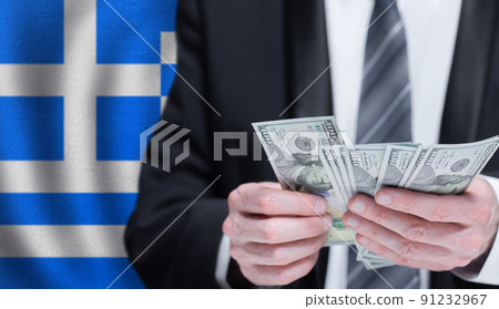 Hands holding dollar money on flag of Greece 91232967