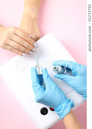 Nail care procedure on pink background, close up 91233782