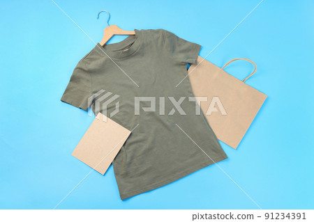 Blank t-shirt, bag and carton sheet on blue background 91234391