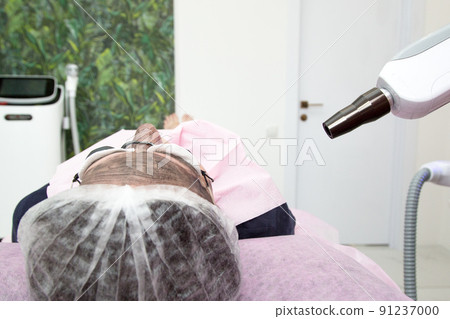 Women's hands hold a device for working with carbon peeling Women's hands hold a device for working with carbon peeling 91237000