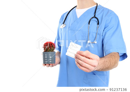 Nurse holds suppositories and cactus, isolated on white background Nurse holds suppositories and cactus, isolated on white background 91237136