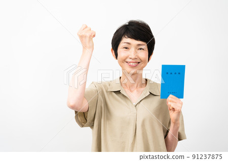 Middle woman doing a guts pose with a pension book Middle woman doing a guts pose with a pension book 91237875