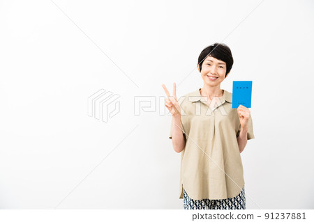 A middle-aged woman holding a pension book and signing a peace sign A middle-aged woman holding a pension book and signing a peace sign 91237881