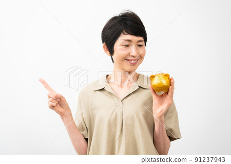 Middle woman pointing at a piggy bank Middle woman pointing at a piggy bank 91237943