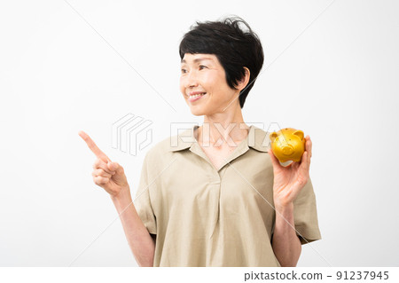 Middle woman pointing at a piggy bank Middle woman pointing at a piggy bank 91237945