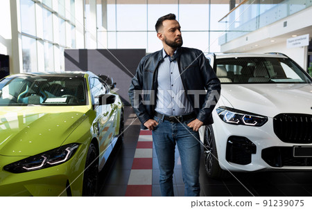 a man in a car dealership chooses a new car 91239075