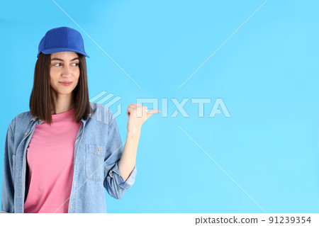Attractive girl in cap on blue background 91239354