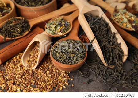 Concept of cooking tea with different types of tea on dark textured background Concept of cooking tea with different types of tea on dark textured background 91239463