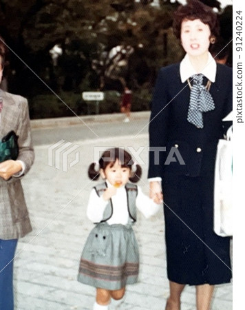 1975年的3歲女孩和媽媽牽手吃糖果 91240224