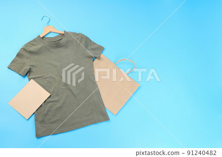 Blank t-shirt, bag and carton sheet on blue background Blank t-shirt, bag and carton sheet on blue background 91240482