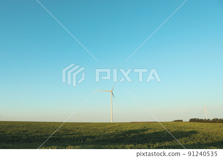 Windmills in field on blue sky background 91240535