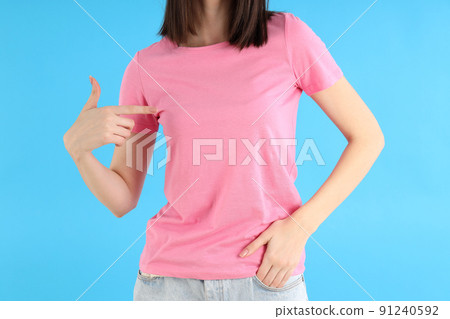 Attractive girl in pink t-shirt on blue background 91240592