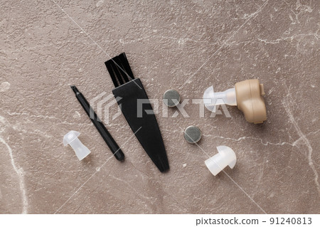 Concept of health care with hearing aid on beige textured background Concept of health care with hearing aid on beige textured background 91240813