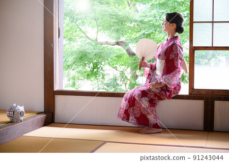 A beautiful woman looking out in a yukata A beautiful woman looking out in a yukata 91243044