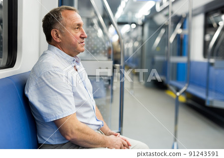 Middle aged man sitting in subway car Middle aged man sitting in subway car 91243591