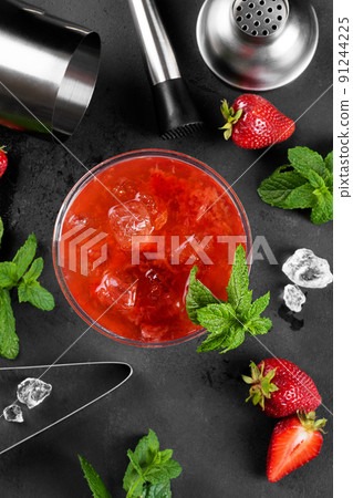 Cold summer strawberry cocktail mojito, margarita, daiquiri in a martini glass on dark background with bartender set Cold summer strawberry cocktail mojito, margarita, daiquiri in a martini glass on dark background with bartender set 91244225