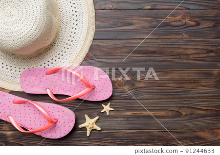 Summer travel concept. Flip flops, summer hat and starfish on white. Top view on colored background Summer travel concept. Flip flops, summer hat and starfish on white. Top view on colored background 91244633