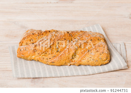 Assortment of freshly baked bread with napkin on rustic table top view. Healthy unleavened bread. French bread Assortment of freshly baked bread with napkin on rustic table top view. Healthy unleavened bread. French bread 91244731