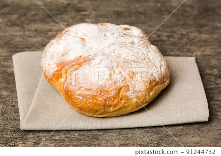 Assortment of freshly baked bread with napkin on rustic table top view. Healthy unleavened bread. French bread Assortment of freshly baked bread with napkin on rustic table top view. Healthy unleavened bread. French bread 91244732
