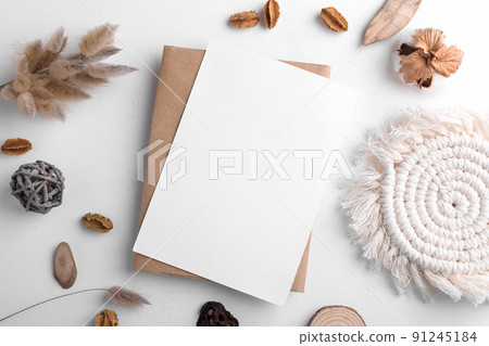 Wedding stationery invitation card mockup 5x7 on white background with envelop and boho decor, vertical card Wedding stationery invitation card mockup 5x7 on white background with envelop and boho decor, vertical card 91245184