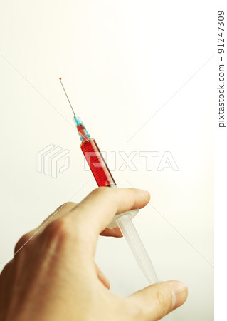 hand holding a syringe 91247309