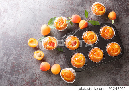 Close-up of apricot yogurt muffins in baking form. horizontal top view Close-up of apricot yogurt muffins in baking form. horizontal top view 91248021