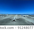 An airplane flapping to the clear sky 91248077