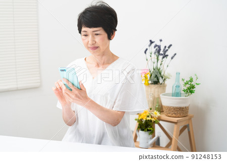 操作智能手機的中產婦女 操作智能手機的中產婦女 91248153