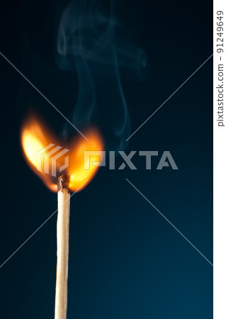 igniting match on blue 91249649
