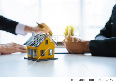 The real estate agent discusses the terms of the home purchase contract and asks the client to sign the documents to legally enter the contract. 91249869