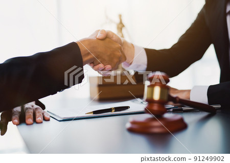 Businessman shaking hands to seal a deal with his partner lawyers or attorneys discussing a contract agreement. 91249902
