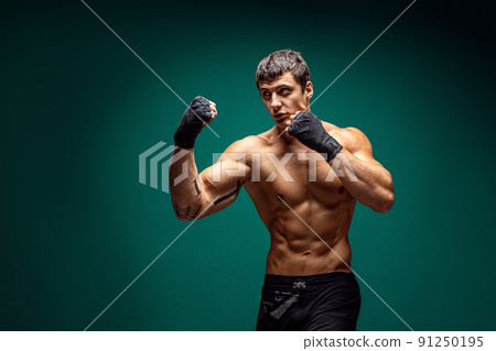 Side view of Male boxer training and practicing swing Isolated on green studio background. Concept of sport, healthy lifestyle 91250195