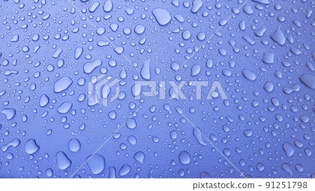 A drop of water on the hood of the car. Water balls after rain or car wash on the surface of purple paint A drop of water on the hood of the car. Water balls after rain or car wash on the surface of purple paint 91251798