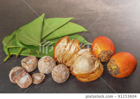 Betel nut or areca nut with betel leaf isolated on dark background. Betel nut or areca nut with betel leaf isolated on dark background. 91253604
