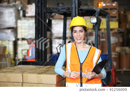 worker in warehouse,  using bar code scanner to scanning box and analyze newly arrived goods.  Working at warehouse.International export business concept 91256009