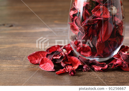 Potpourri in a glass bottle on a wood background Potpourri in a glass bottle on a wood background 91256667