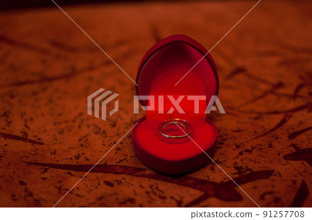 Gold wedding ring in the dark red box Gold wedding ring in the dark red box 91257708