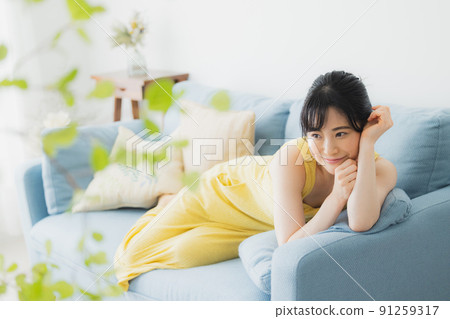 A woman relaxing on the sofa A woman relaxing on the sofa 91259317