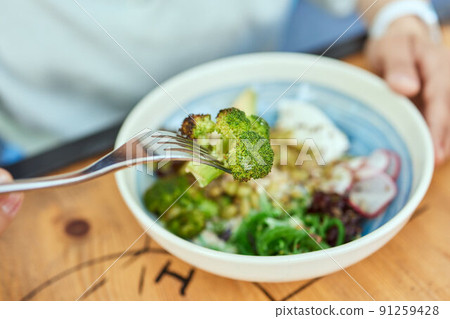 Woman eating quinoa broccoli salad. Eat healthy food lifestyle concept. Woman eating quinoa broccoli salad. Eat healthy food lifestyle concept. 91259428