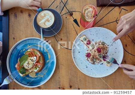 Female hand holds a piece of cottage cheese casserole with the cake server. Cheese pie with blackberry and blueberry. 91259457