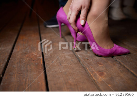 a woman's foot in a shoe got stuck in the wood floor. hole. a woman's foot in a shoe got stuck in the wood floor. hole. 91259560