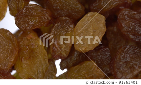 Raisins fall on glass on a bright white background. Raisins macro bottom view. 91263401