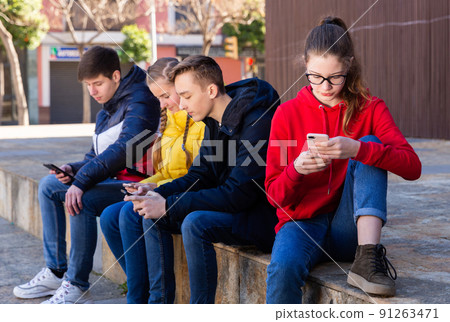 Teens outdoor with smartphones Teens outdoor with smartphones 91263471