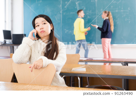 Tired asian student girl talking on phone 91263490