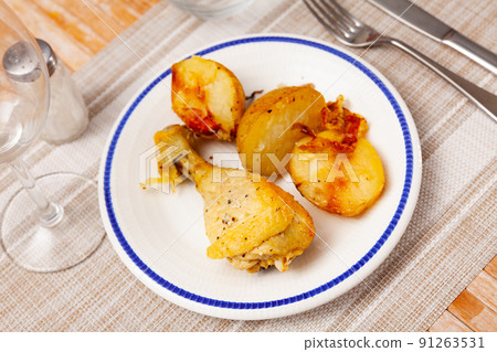 Baked chicken drumstick with vegetable garnish of fried potatoes 91263531