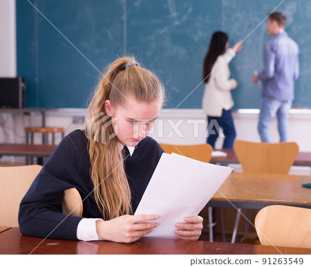Young sad girl preparing for the exam in classroom Young sad girl preparing for the exam in classroom 91263549
